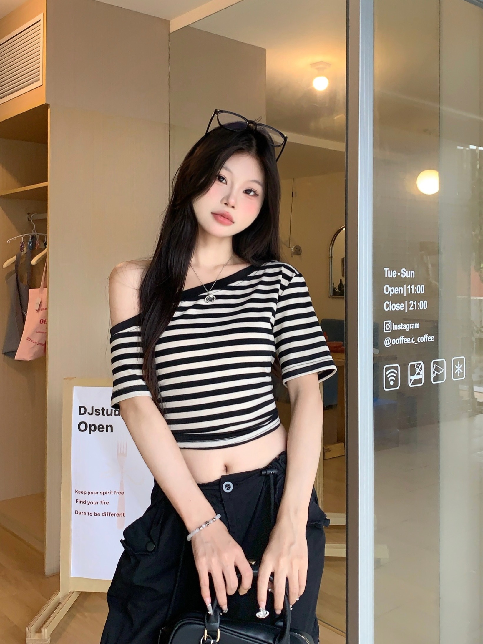 Real shot of slanted shoulder striped short-sleeved T-shirt for women in summer. Irregular, chic and beautiful off-shoulder tight cropped top.